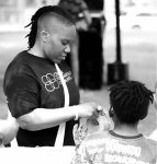 A person in a black T-shirt pulls at a tape roll