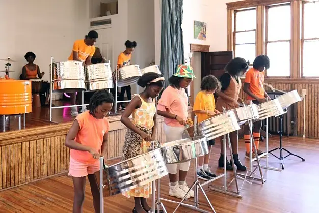 Young members of the U. of Orange's steel pan band, playing their steel pans